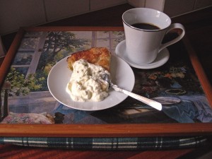 Rabarberkaka med en klick grädde och en kopp kaffe